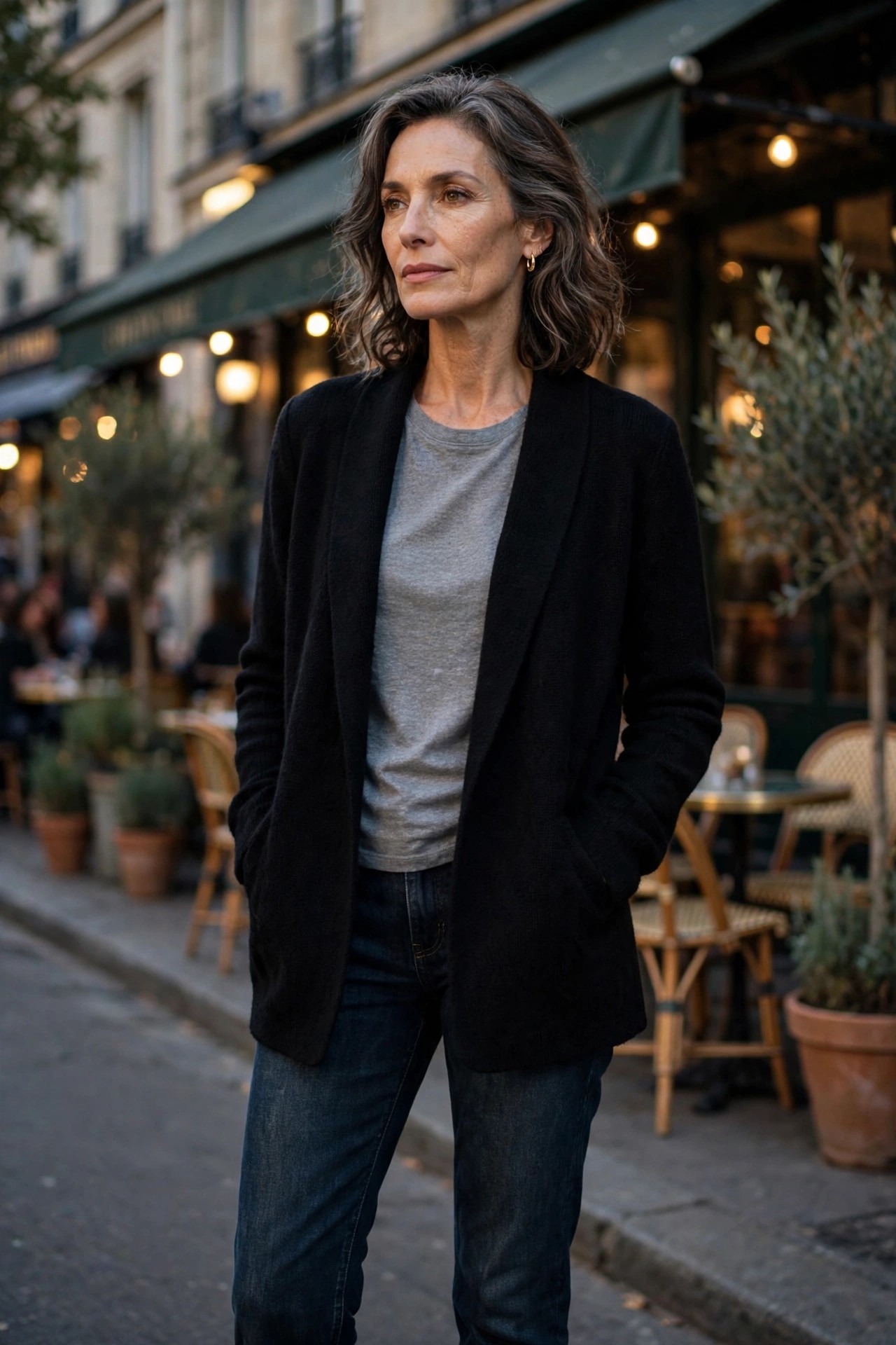 Woman in her 50s in a black knit blazer over a grey tee with dark jeans and black loafers