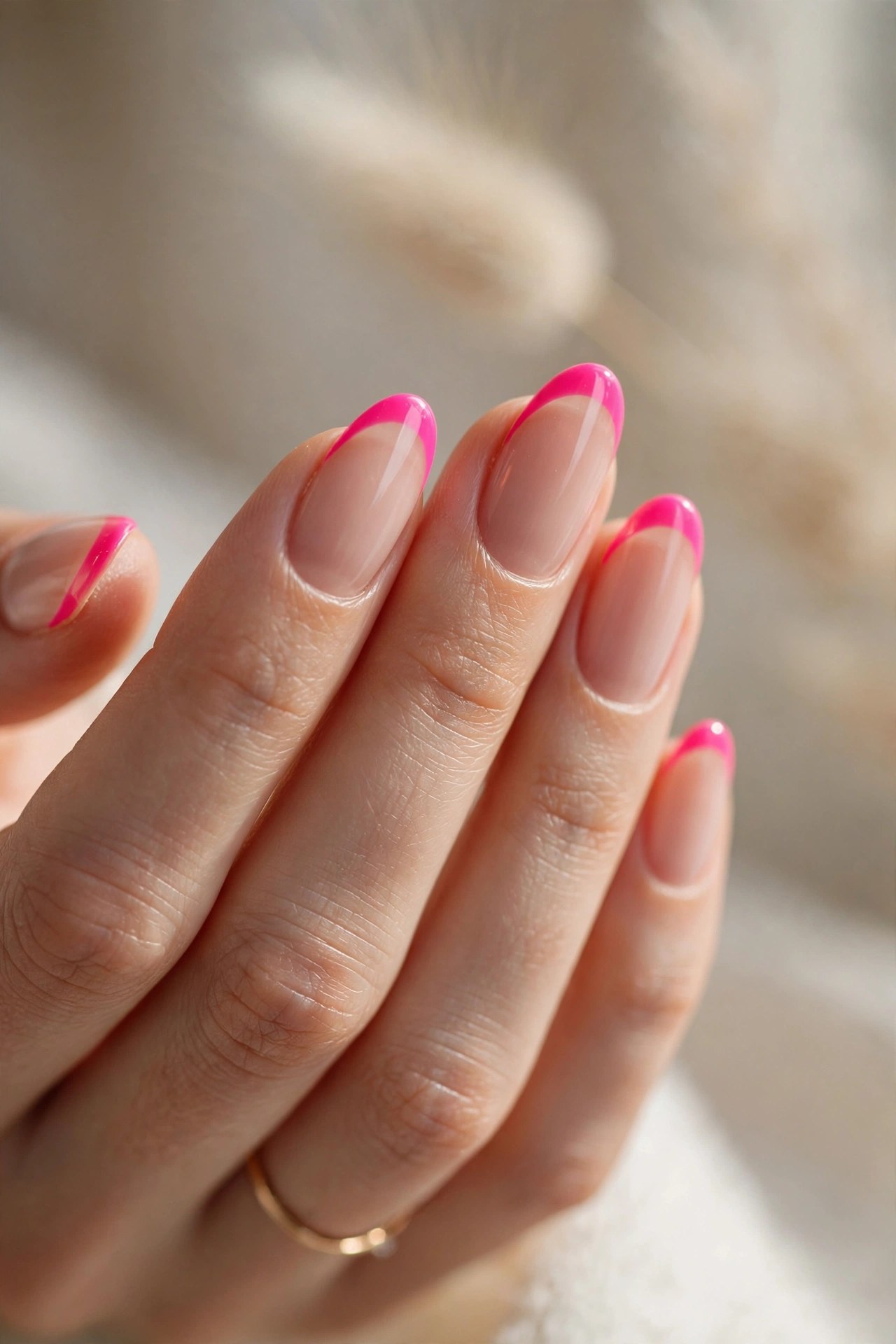 Elegant woman's hand with nude nails and neon pink french tips