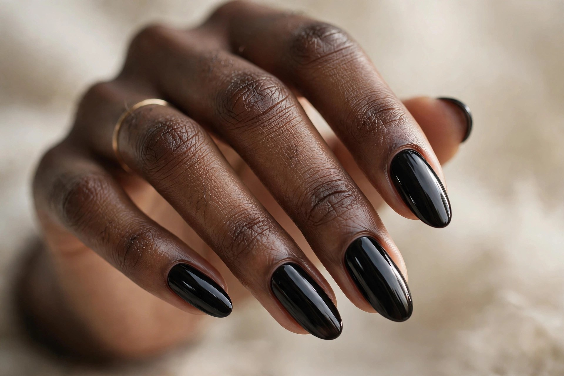 Dark-skinned woman's hand with jet black glossy manicured nails