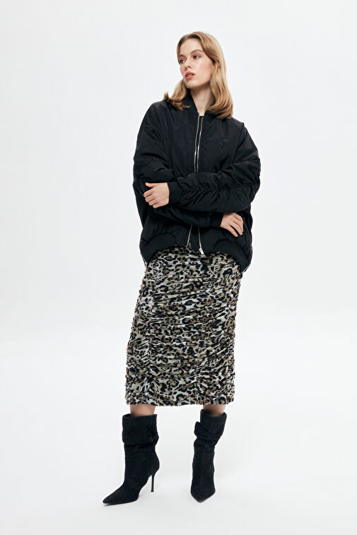 Camel bomber jacket paired with a leopard midi skirt and black ankle boots