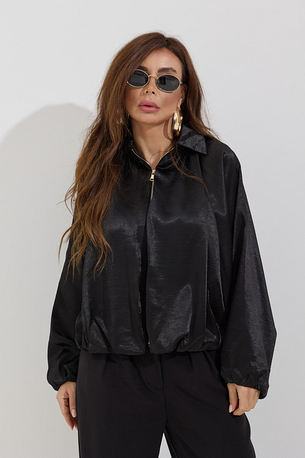 Satin bomber jacket with black trousers and statement earrings, evening look