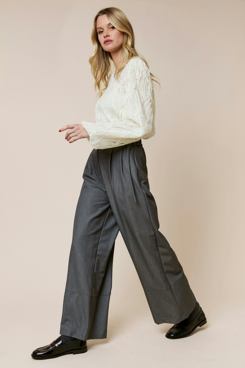 Cream cable knit sweater with grey wool trousers and black loafers