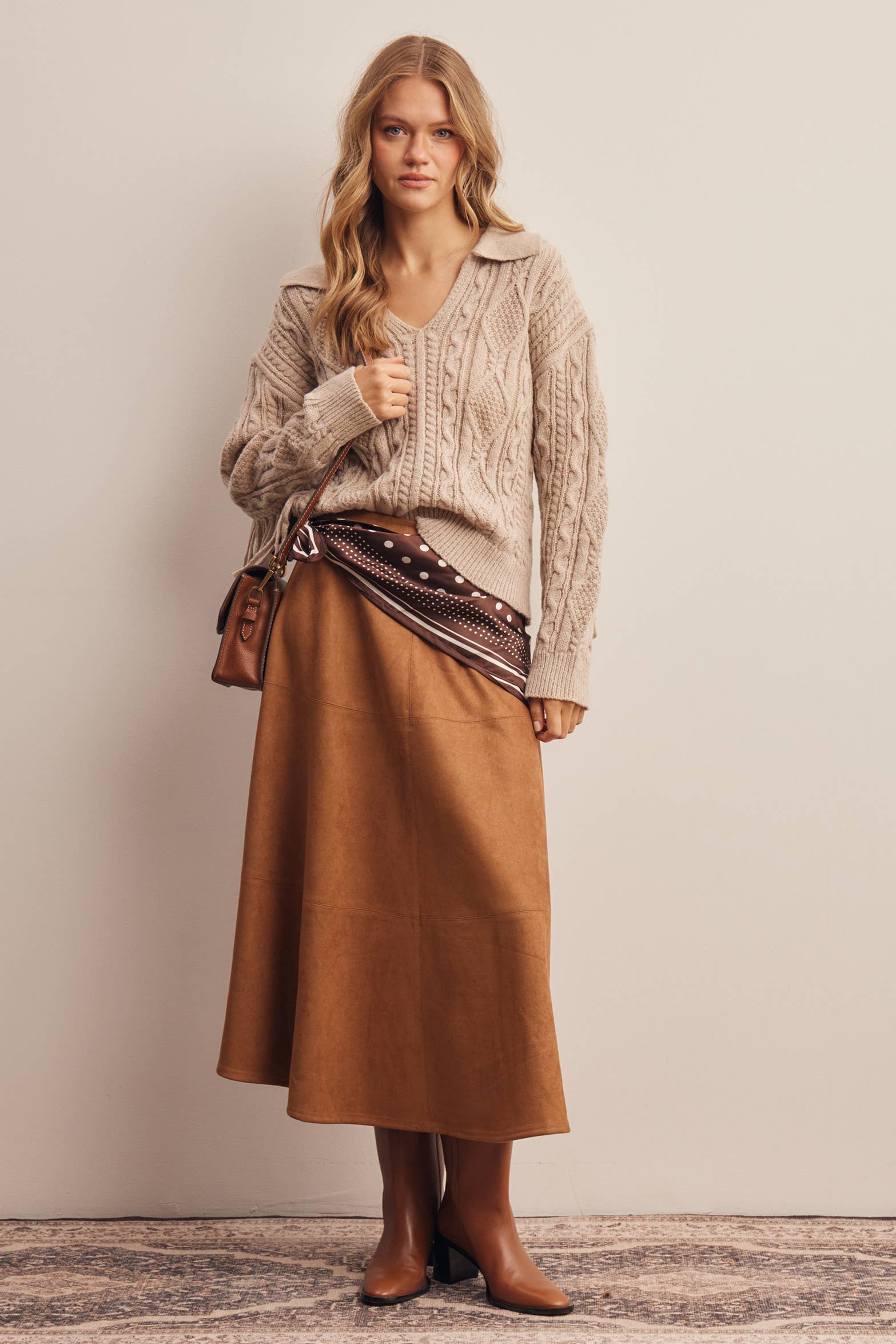 Ivory cable knit sweater with brown suede midi skirt and brown boots
