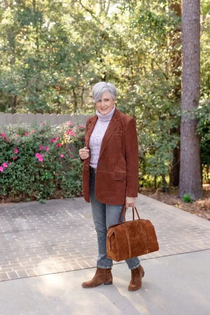 Woman over 50 wearing straight-leg jeans, a rust suede blazer and brown Chelsea boots