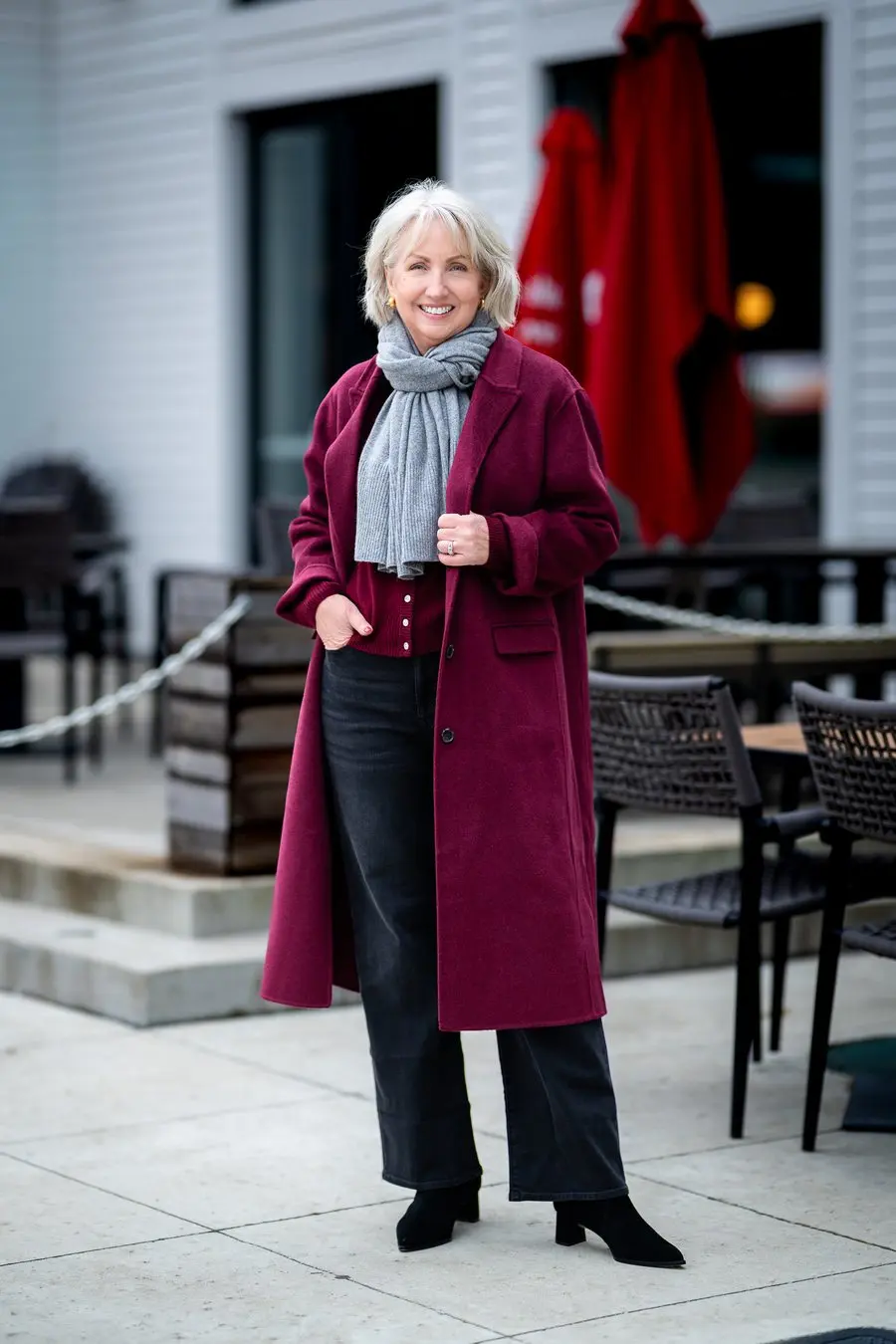 Woman over 50 wearing long wide-leg jeans falling over Chelsea boots