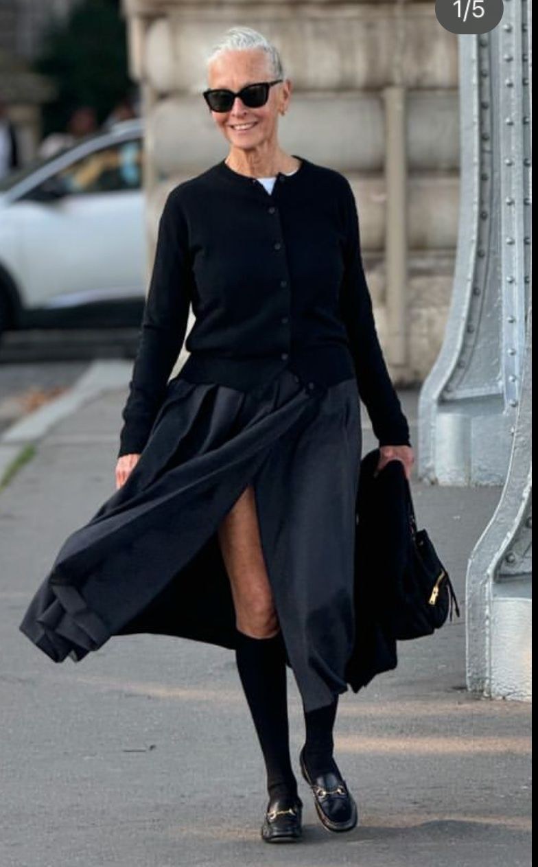 Woman over 50 wearing a fitted button cardigan tucked into a pencil skirt