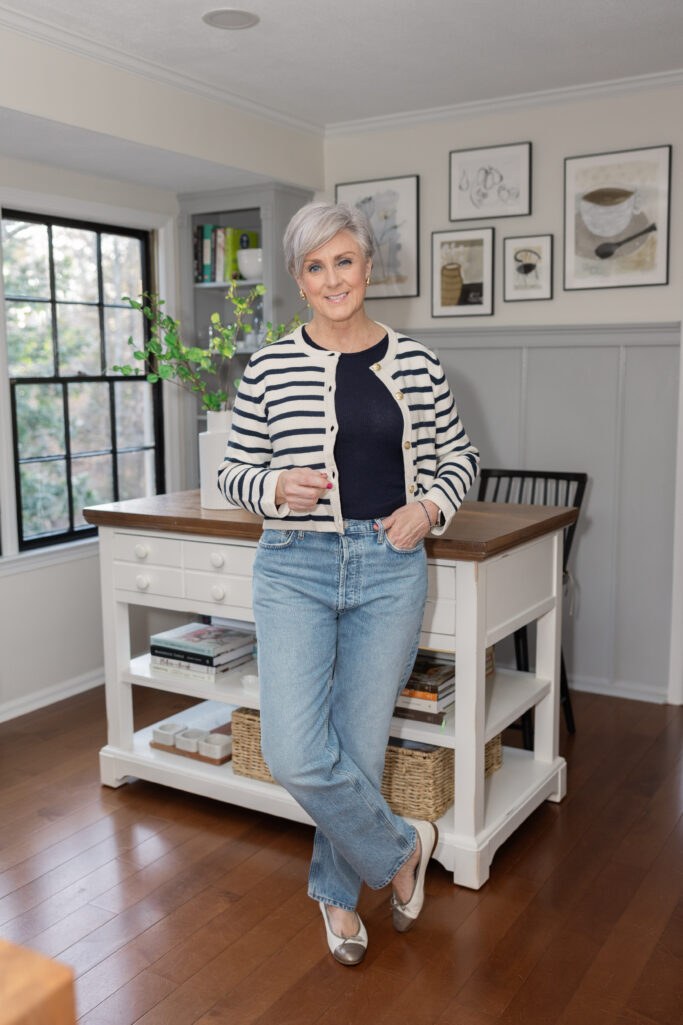 Petite woman over 50 in a striped cropped cardigan with high-rise jeans