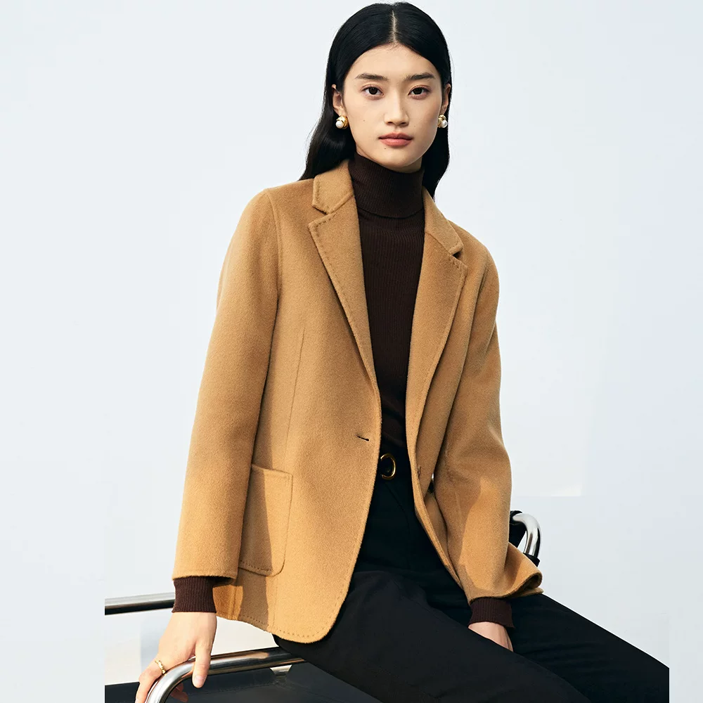 Woman over 50 in black turtleneck and camel blazer layered fall outfit