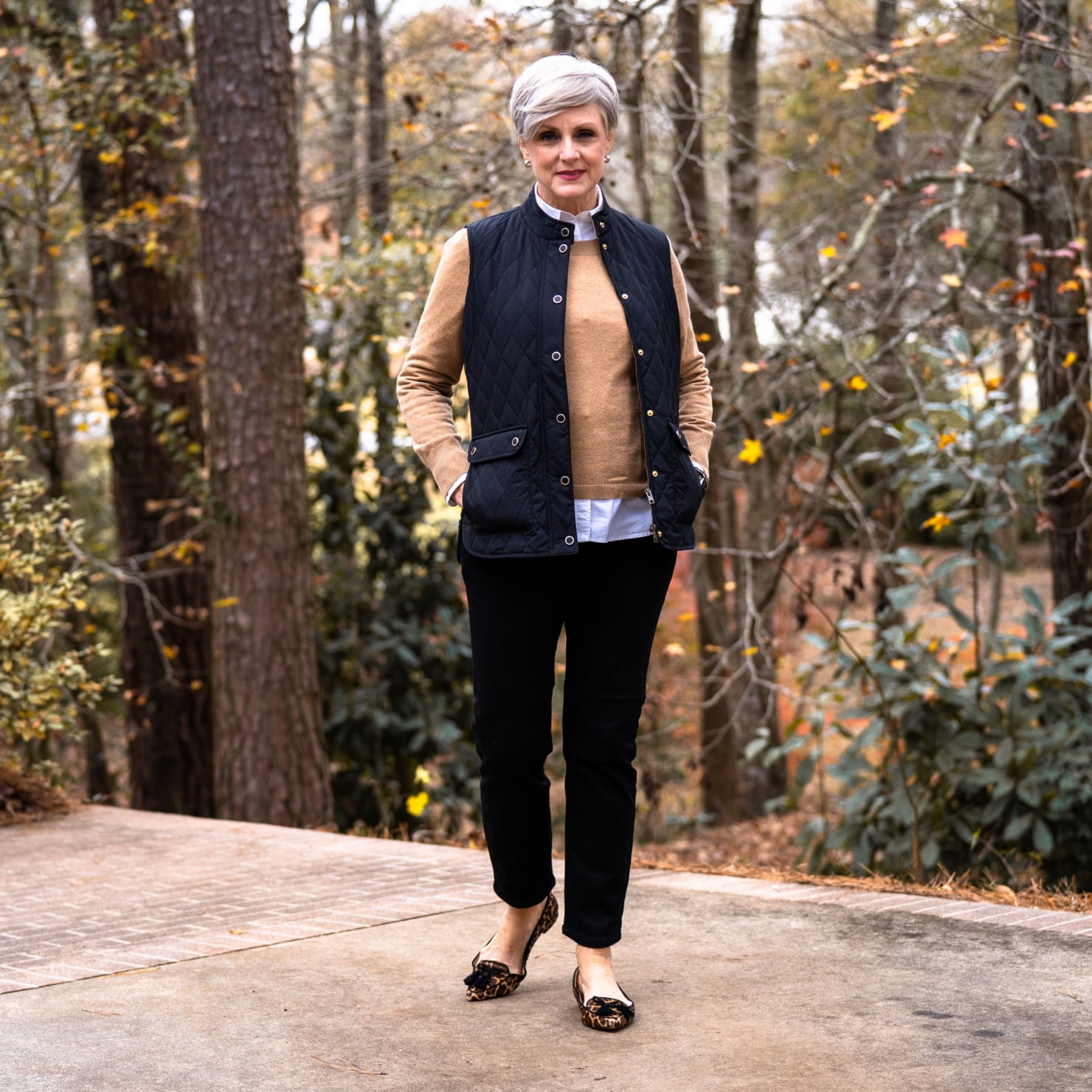 Woman over 50 wearing sweater vest and barn jacket fall layered look