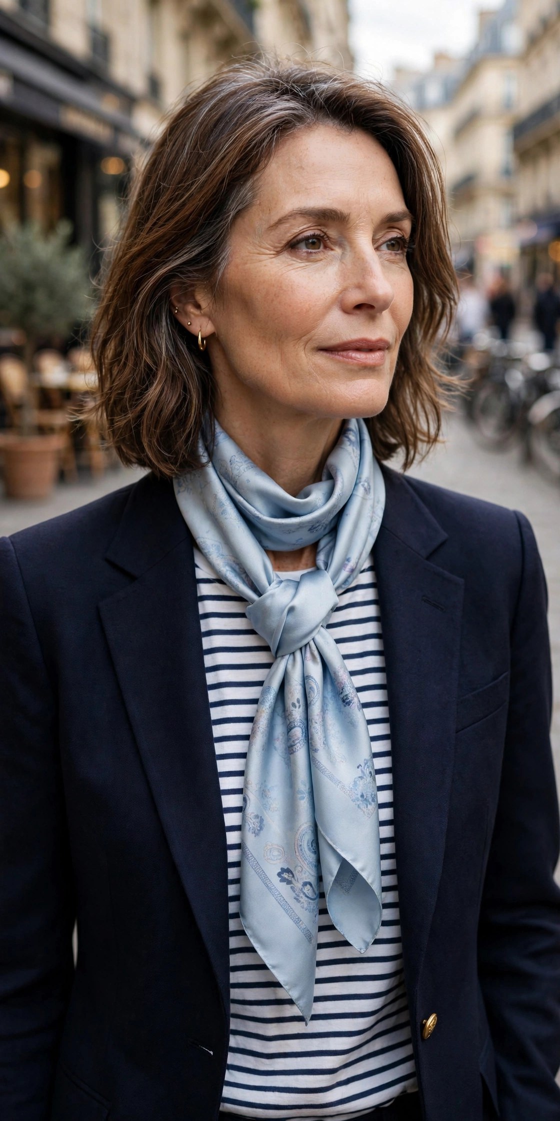 Woman over 50 in a navy blazer with a silk scarf tied in a classic loop knot