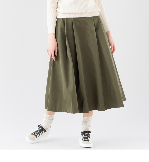 Olive satin midi skirt with cream sweater and white sneakers, fall outfit over 50