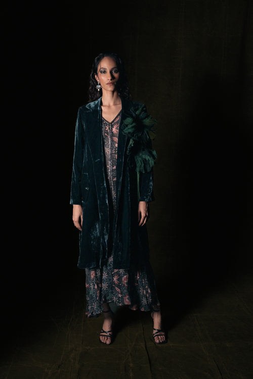 Forest green velvet dress with long coat and statement earrings, evening outfit over 50