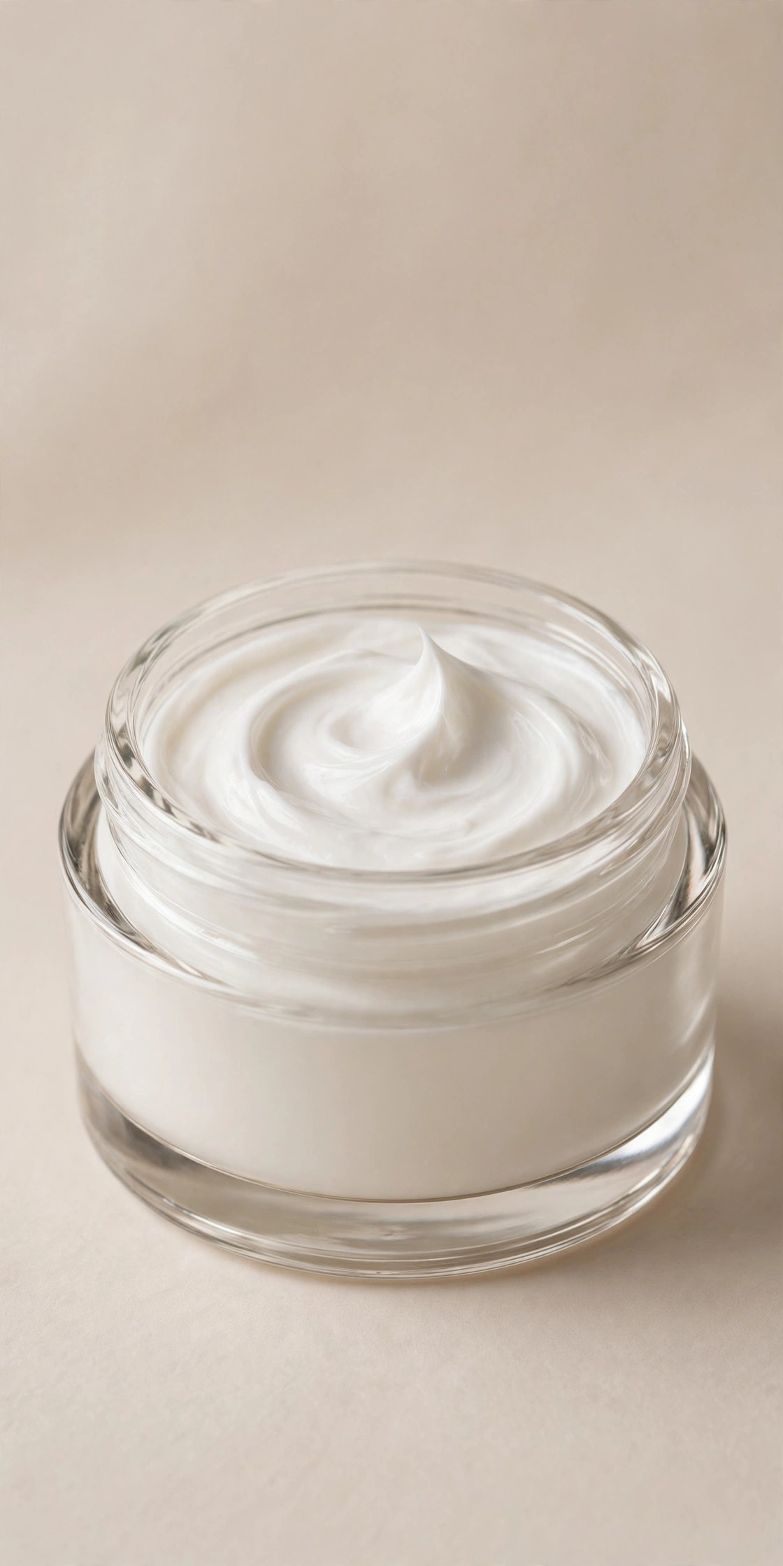 Open glass cream jar with rich white ceramide moisturizer swirl