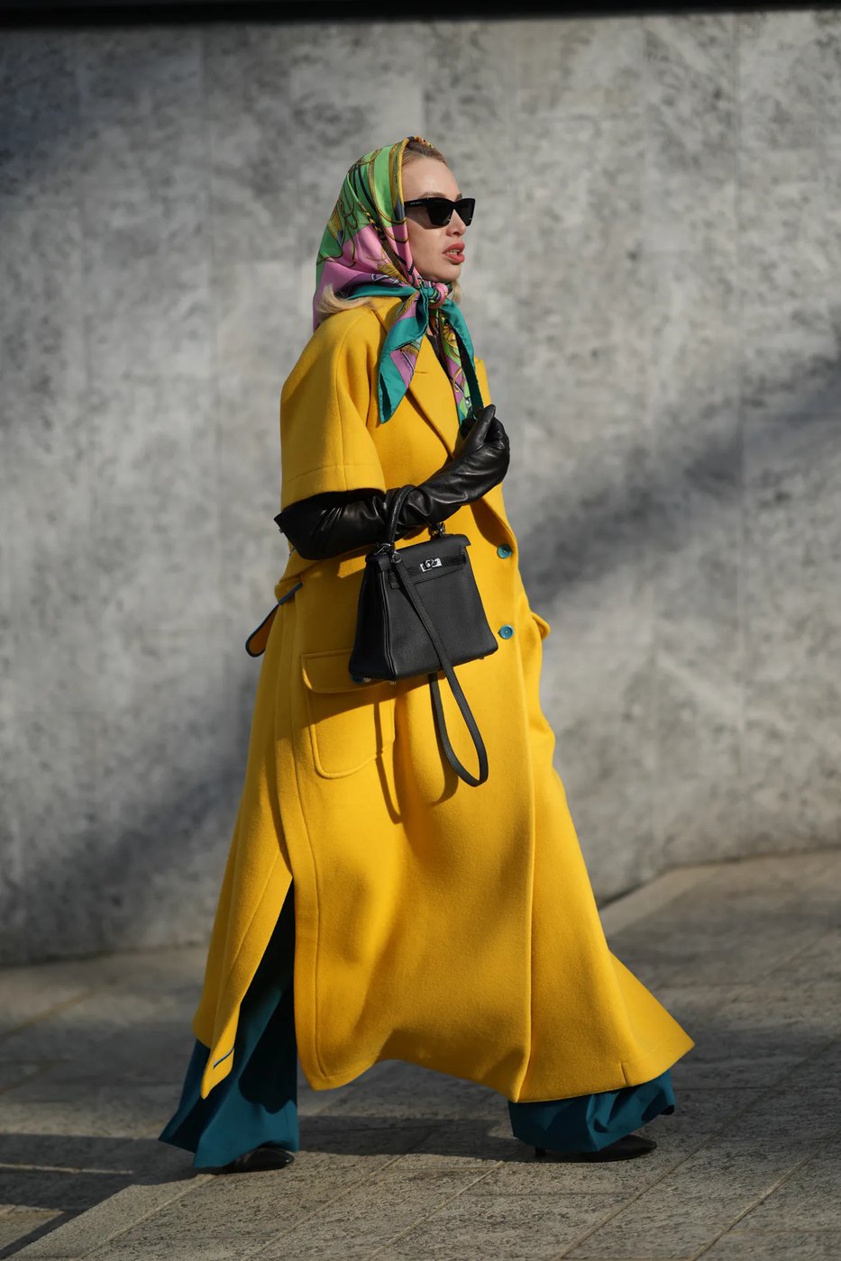 Mustard yellow scarf with a grey coat and black trousers on a mature woman
