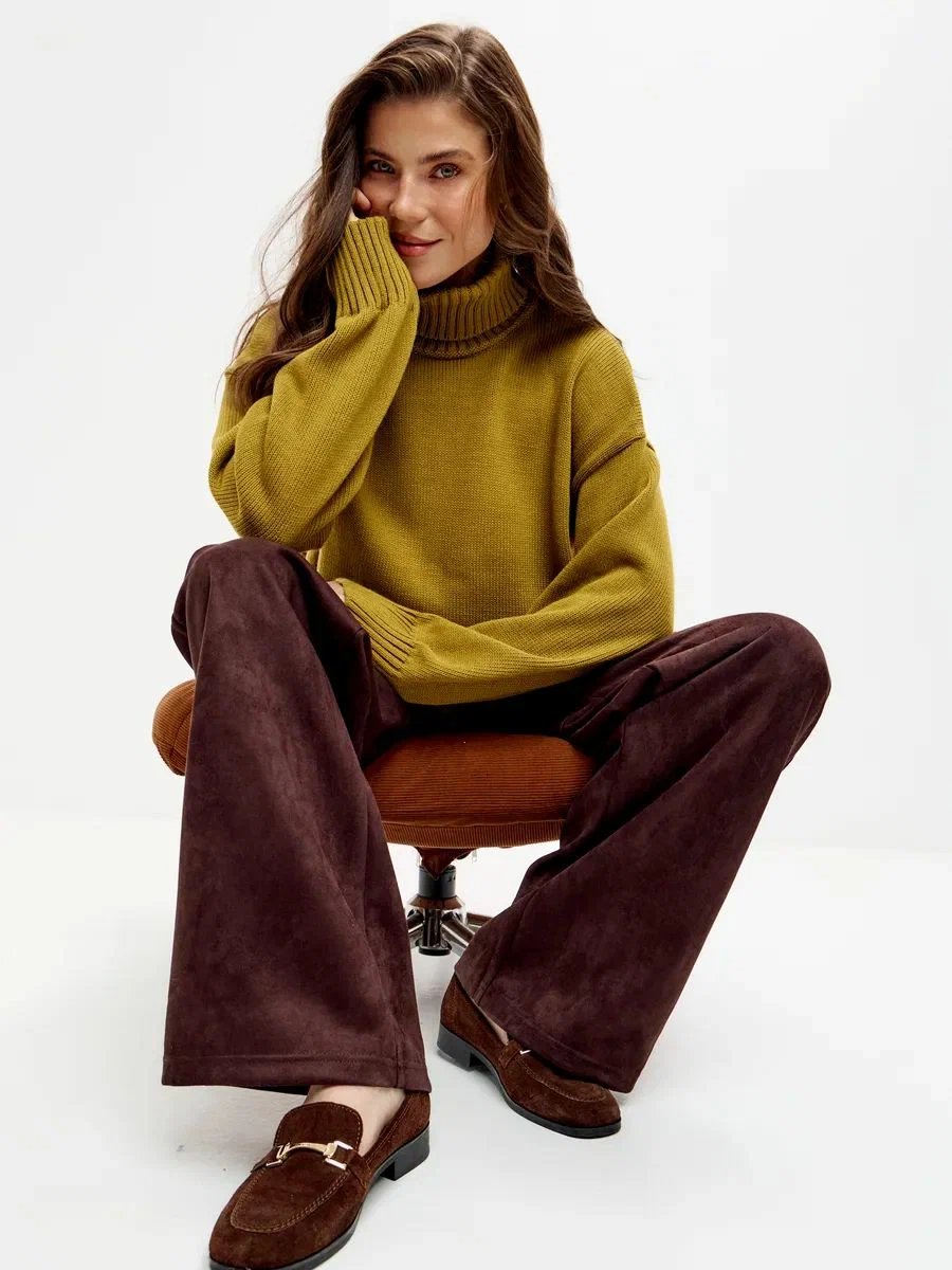 Woman over 50 in a mustard sweatshirt with chocolate corduroy pants and loafers