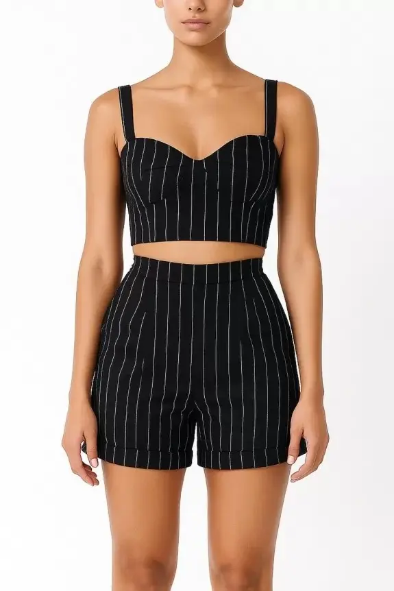 Woman wearing a black pinstripe bustier crop top with matching pinstripe tailored shorts