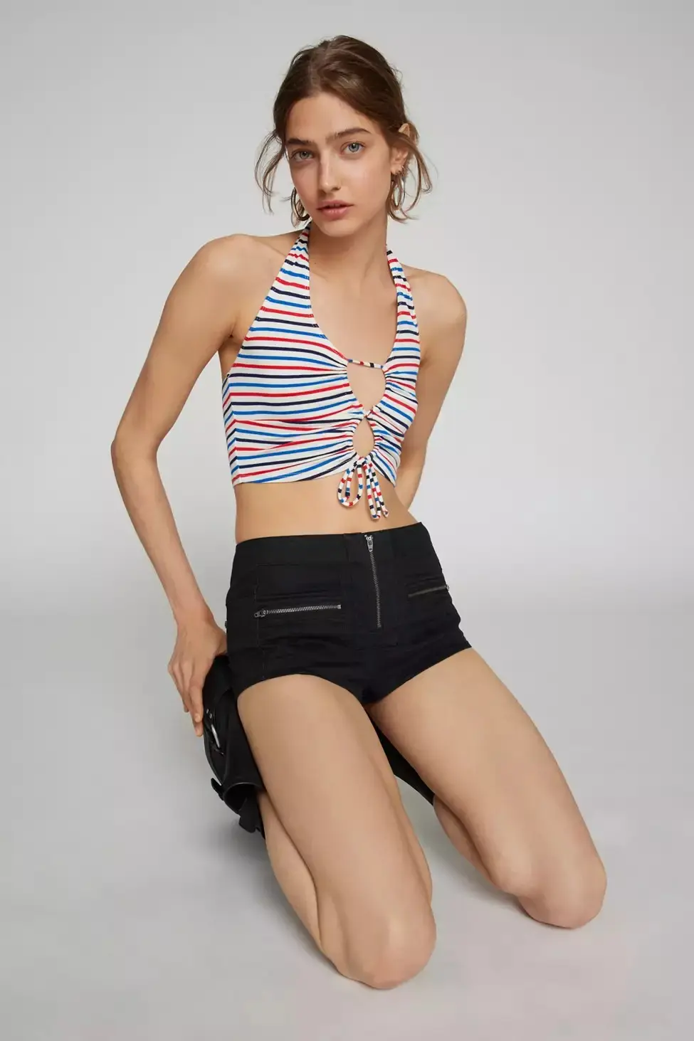 Woman wearing a red white and blue striped halter top with black micro shorts