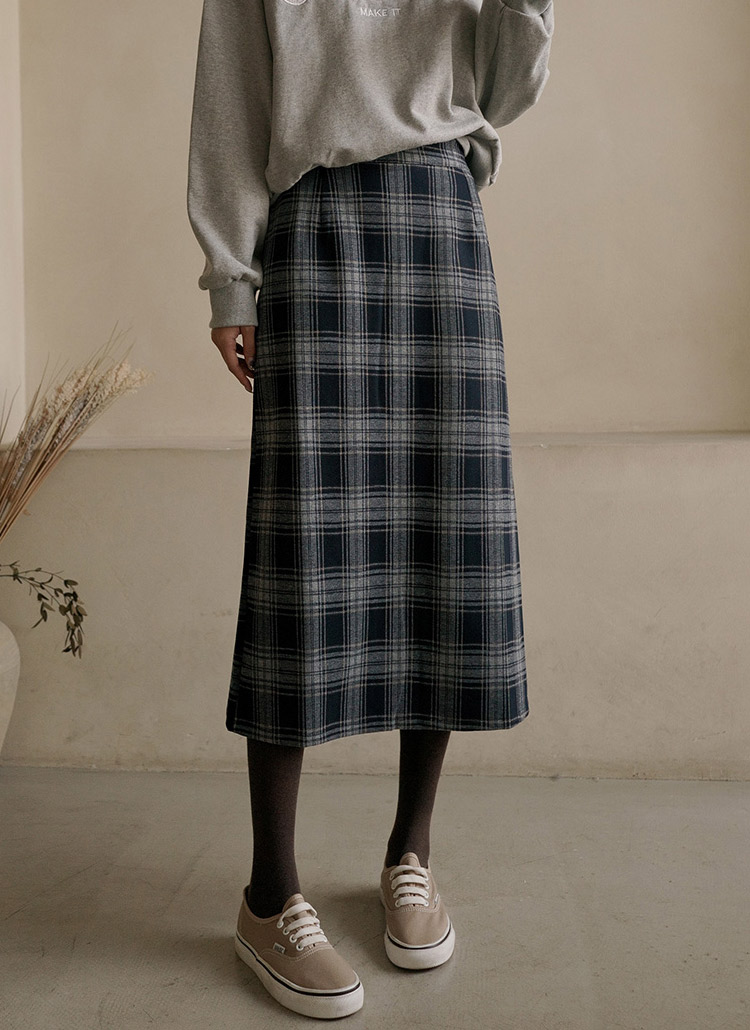 October outfit idea 10: grey sweatshirt plaid midi skirt sneakers on a woman over 50