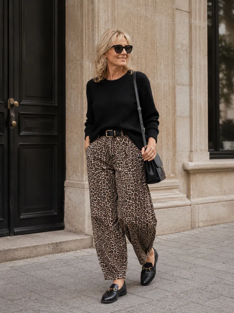 October outfit idea 17: black turtleneck leopard trousers red loafers on a woman over 50