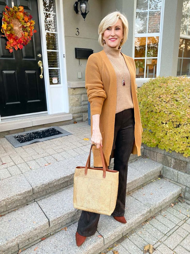 October outfit idea 7: camel cardigan cream turtleneck dark jeans on a woman over 50