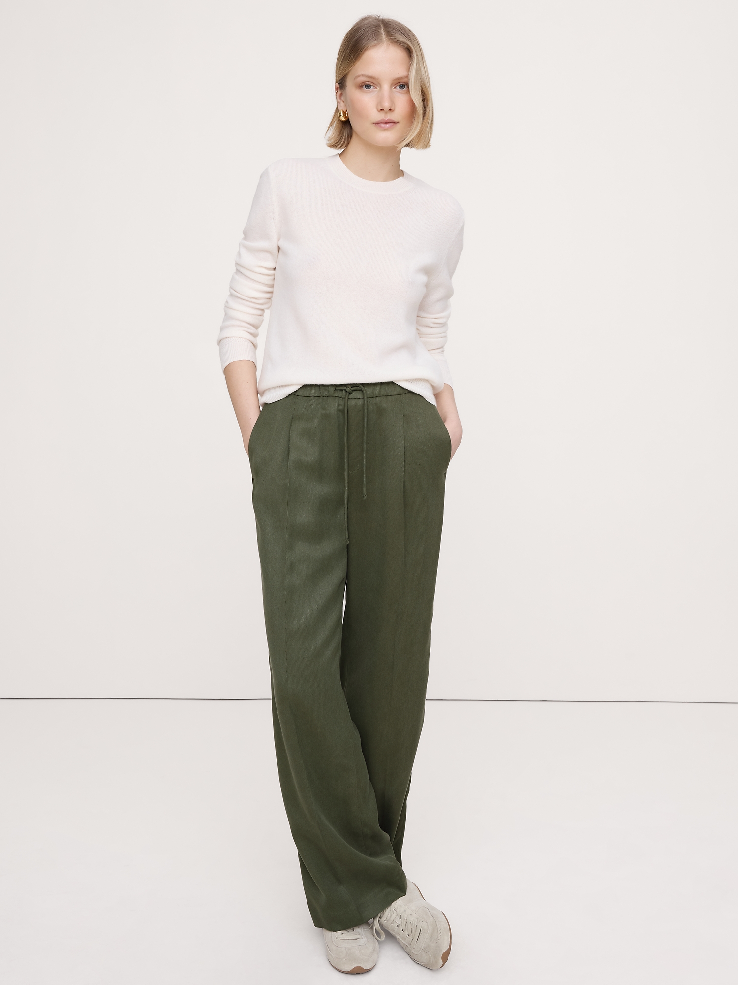 Olive green sweater with cream jeans and white sneakers, casual fall outfit