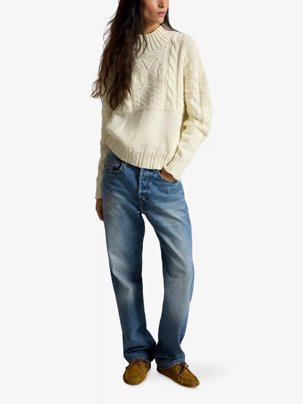 Woman over 50 in cream cable knit sweater, light jeans and brown boots at pumpkin patch