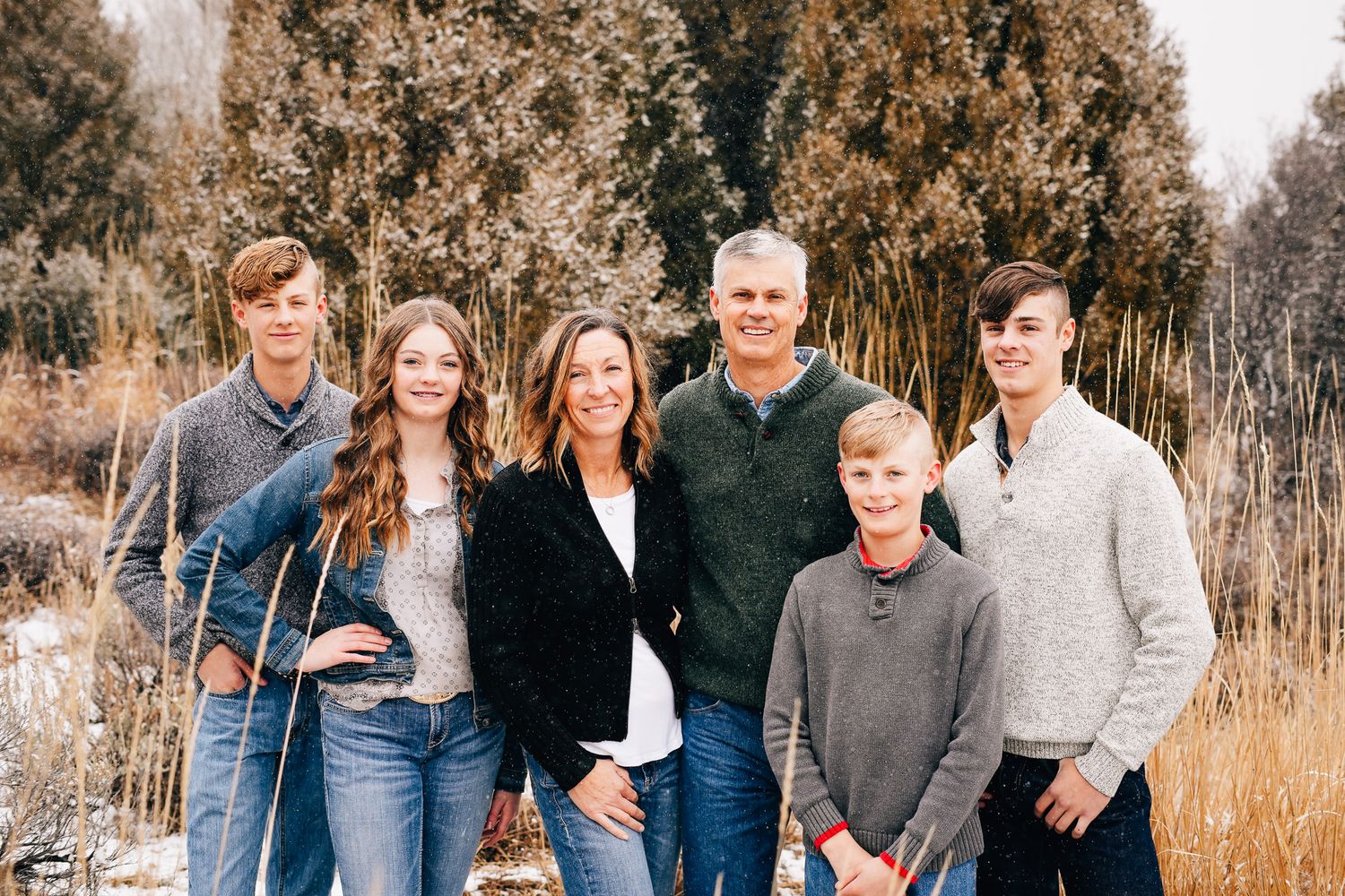 Coordinated family outfits in sage, cream and dusty blue for fall photos