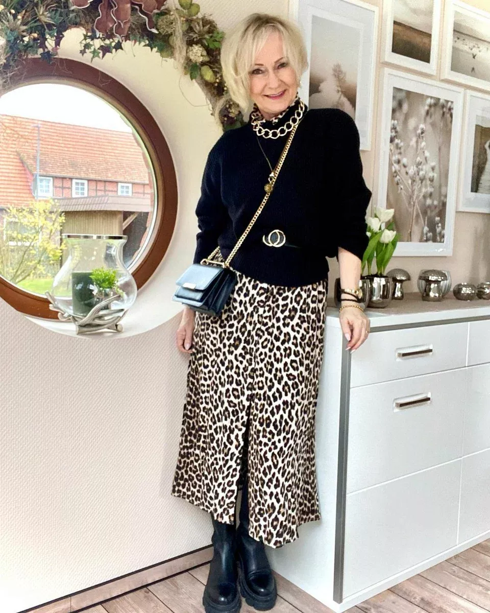 Woman over 50 in black turtleneck and leopard midi skirt for fall couple photos