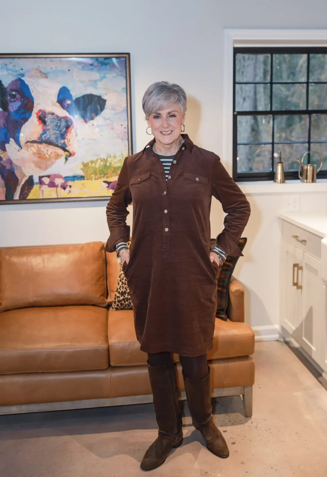 Woman over 60 wearing tailored shirt dress with thin belt and boots