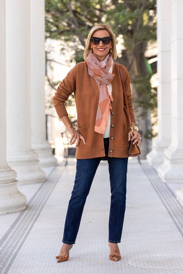 Camel twinset cardigan with dark wide jeans and white sneakers — modern twinset outfit for women over 50