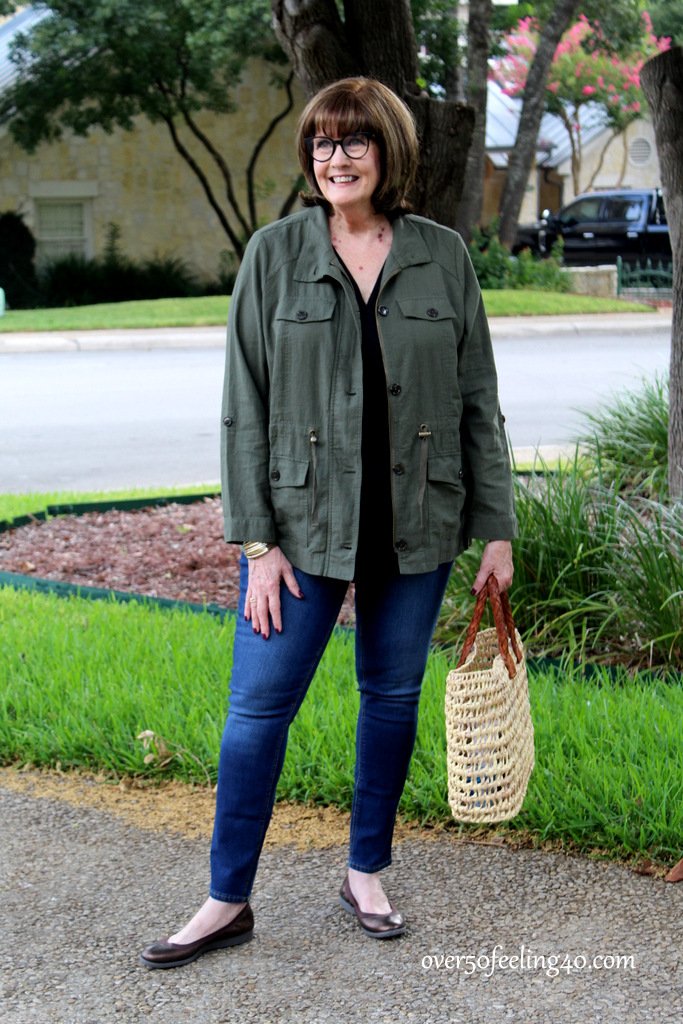 Olive utility jacket over black top with pointed flats, woman over 50